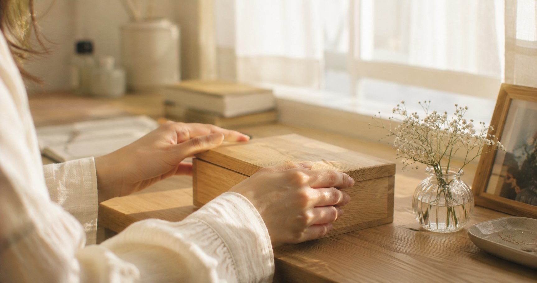 朝の光の中、小さな木箱の蓋をそっと閉じる手元