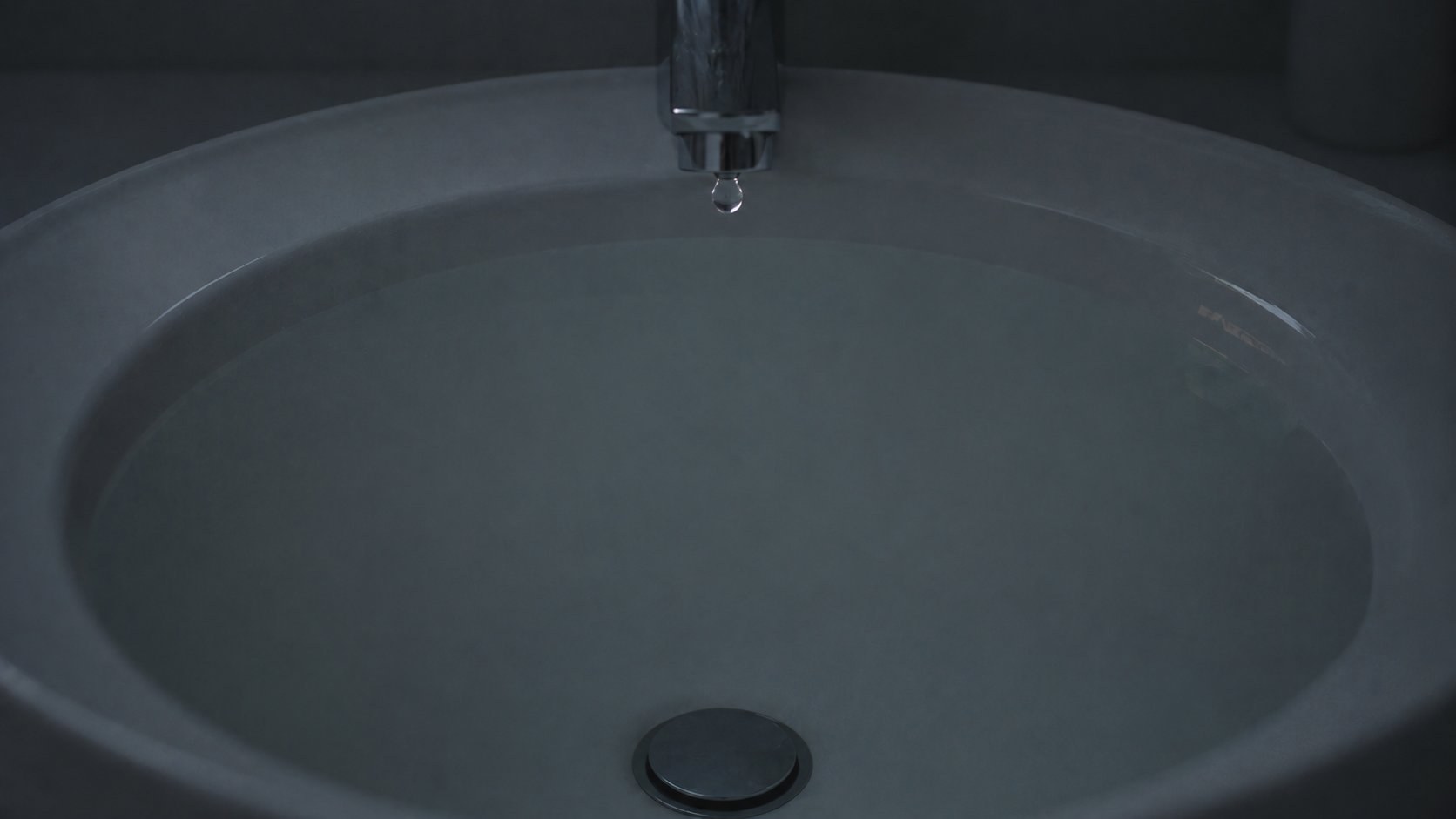縁まで水を張った洗面ボウルに落ちる一滴